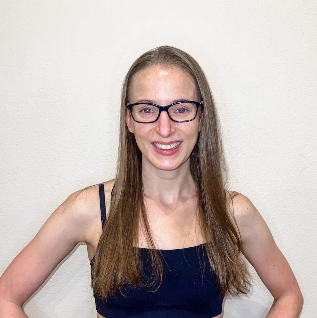 A woman with glasses smiling for the camera.