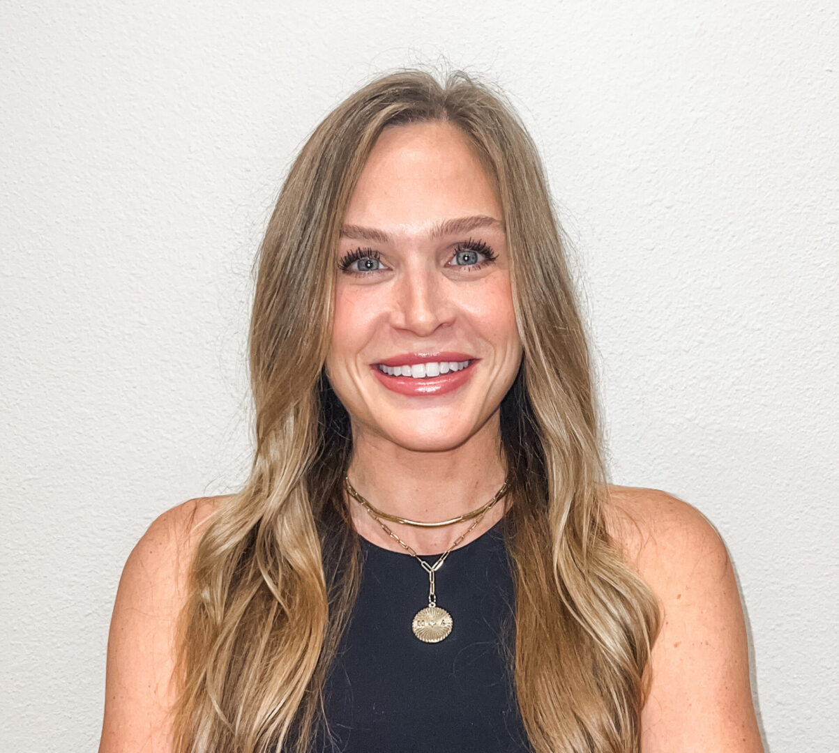 A woman with long hair and wearing a necklace.