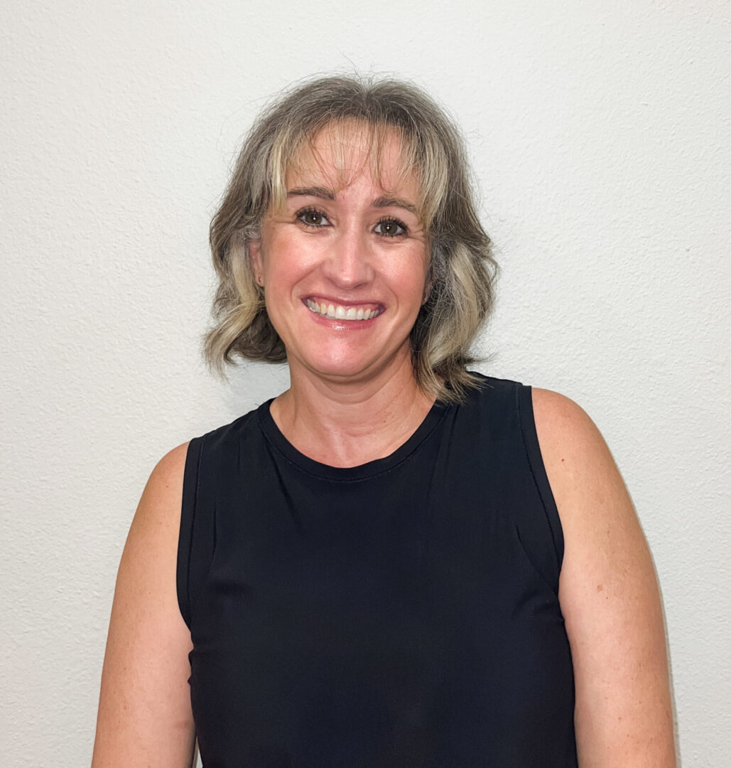 A woman in black shirt smiling for the camera.